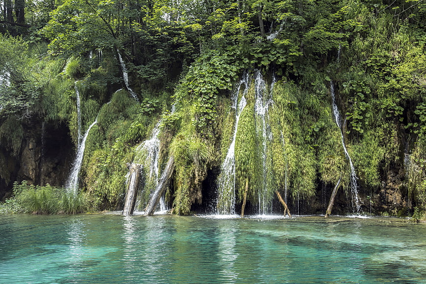 Serene Waterfalls Cascading into Turquoise Lake in Lush Forest