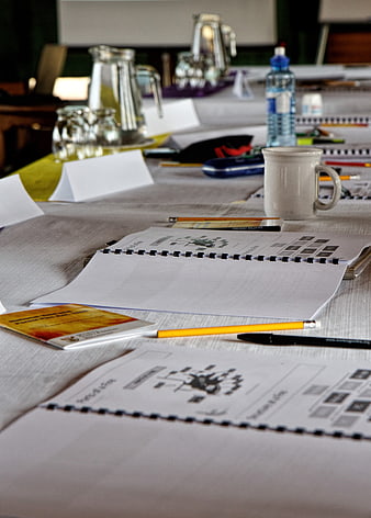 Conference table setup with notebooks, pencils, and water bottles
