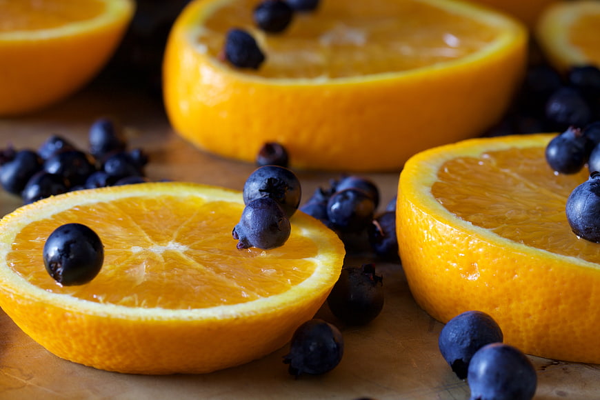 Fresh Sliced Oranges and Blueberries on Wooden Surface