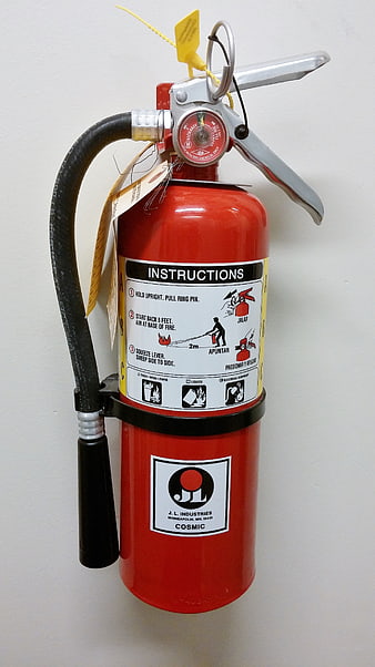 Red Fire Extinguisher With Instruction Label On White Wall