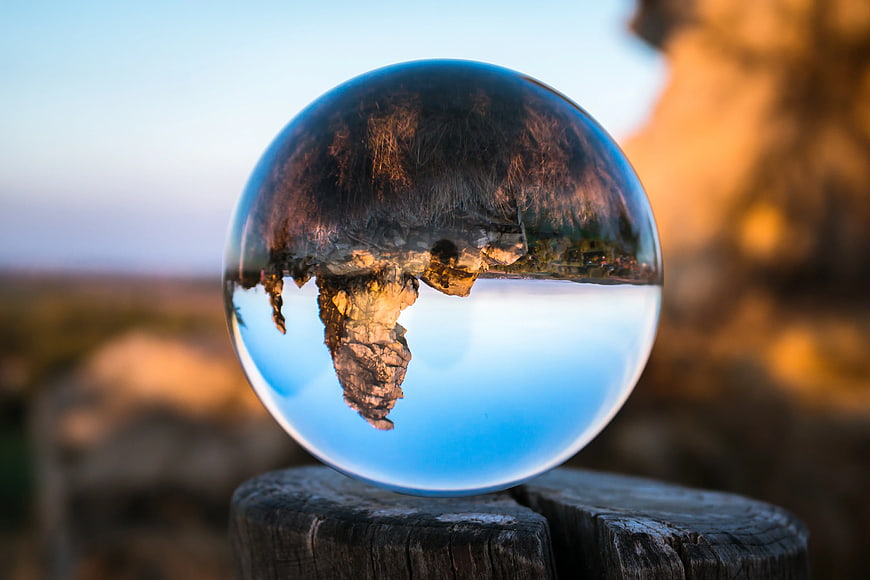 Crystal Ball Reflecting Inverted Landscape at Sunset