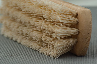 Close-up of natural bristle cleaning brush on textured gray surface