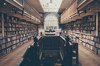Interior of a classic two-story library with wooden bookshelves