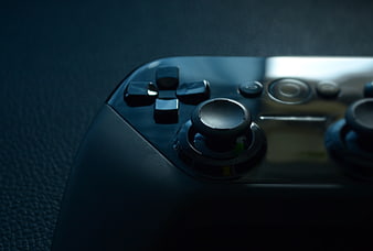 Close-up of black game controller on dark textured surface