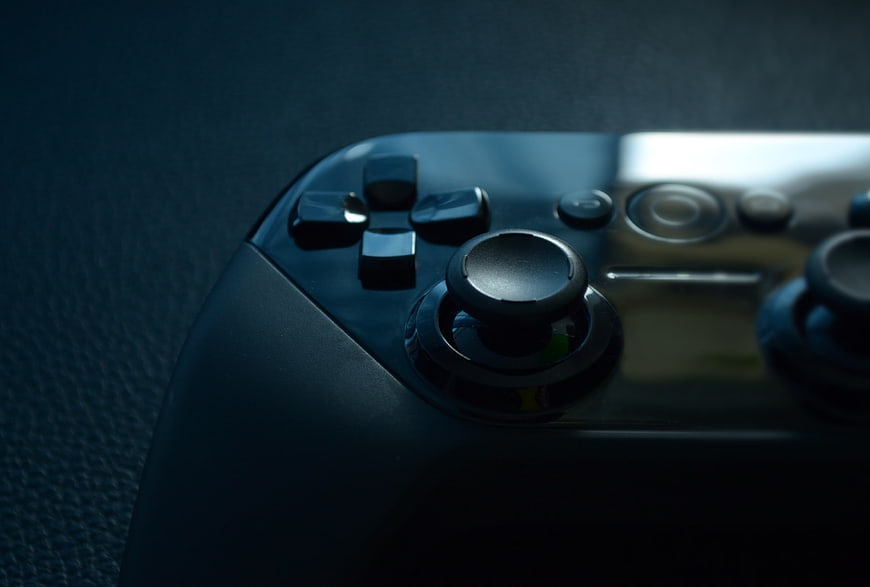 Close-up of black game controller on dark textured surface