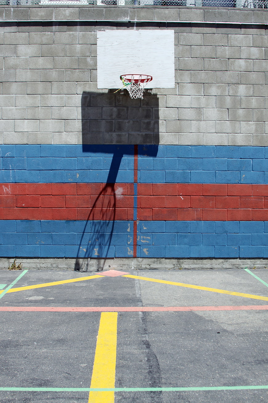 Urban Basketball Hoop Against Colorful Brick Wall