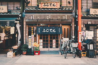 Traditional Japanese Restaurant Facade with Bicycles and Noren Curtains
