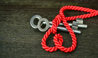 Silver Keys Tied With Red Cord On Dark Wood
