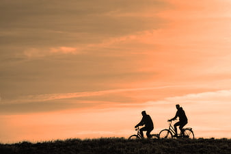 Silhouette of Two Cyclists Riding at Sunset