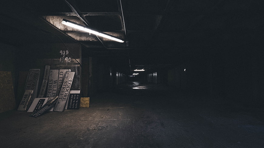 Dark abandoned underground tunnel with street signs