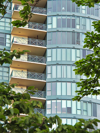 Modern Apartment Building with Balconies and Green Foliage