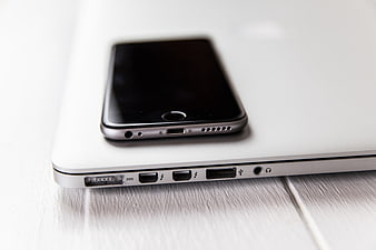 Close-up of Smartphone and Laptop Ports on White Desk