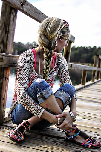 Blonde Woman Sitting Cross-Legged On Wooden Pier