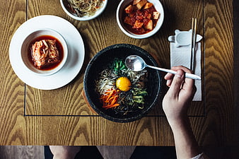 Top View of Korean Bibimbap and Kimchi on Wooden Table