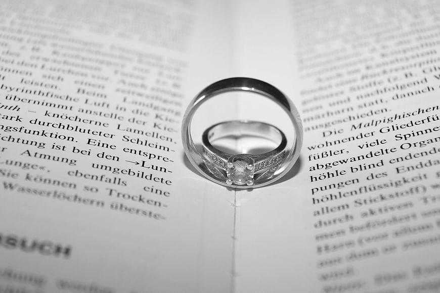 Black and white engagement ring on open book page