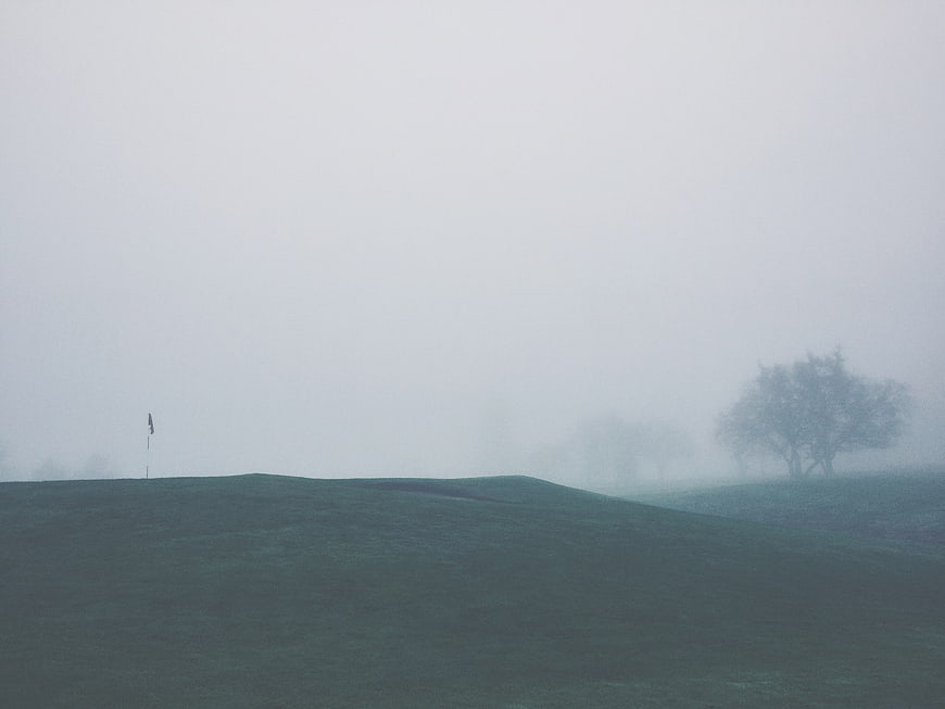 Misty Golf Course Green with Flag and Trees