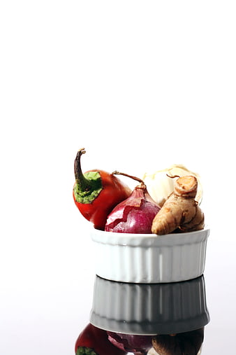 Fresh vegetables in white ramekin with reflection