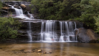 Serene Tiered Waterfall in Lush Forest Landscape