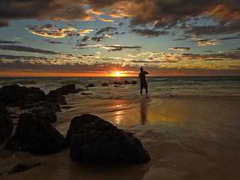 Silhouette of Man Fishing on Beach at Sunset