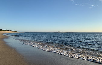 Serene Beach Landscape with Gentle Waves and Distant Island