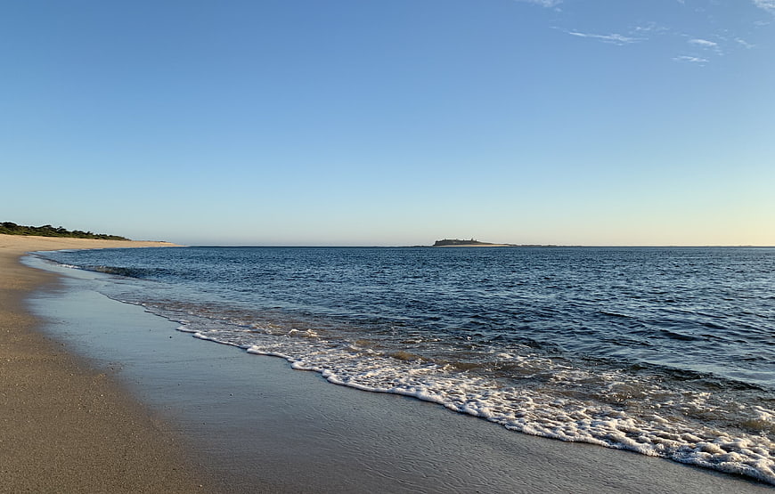 Serene Beach Landscape with Gentle Waves and Distant Island