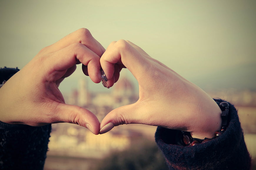Hands forming heart shape with Florence skyline background