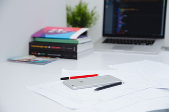 Minimalist Workspace with iPhone, Sketches, and Laptop