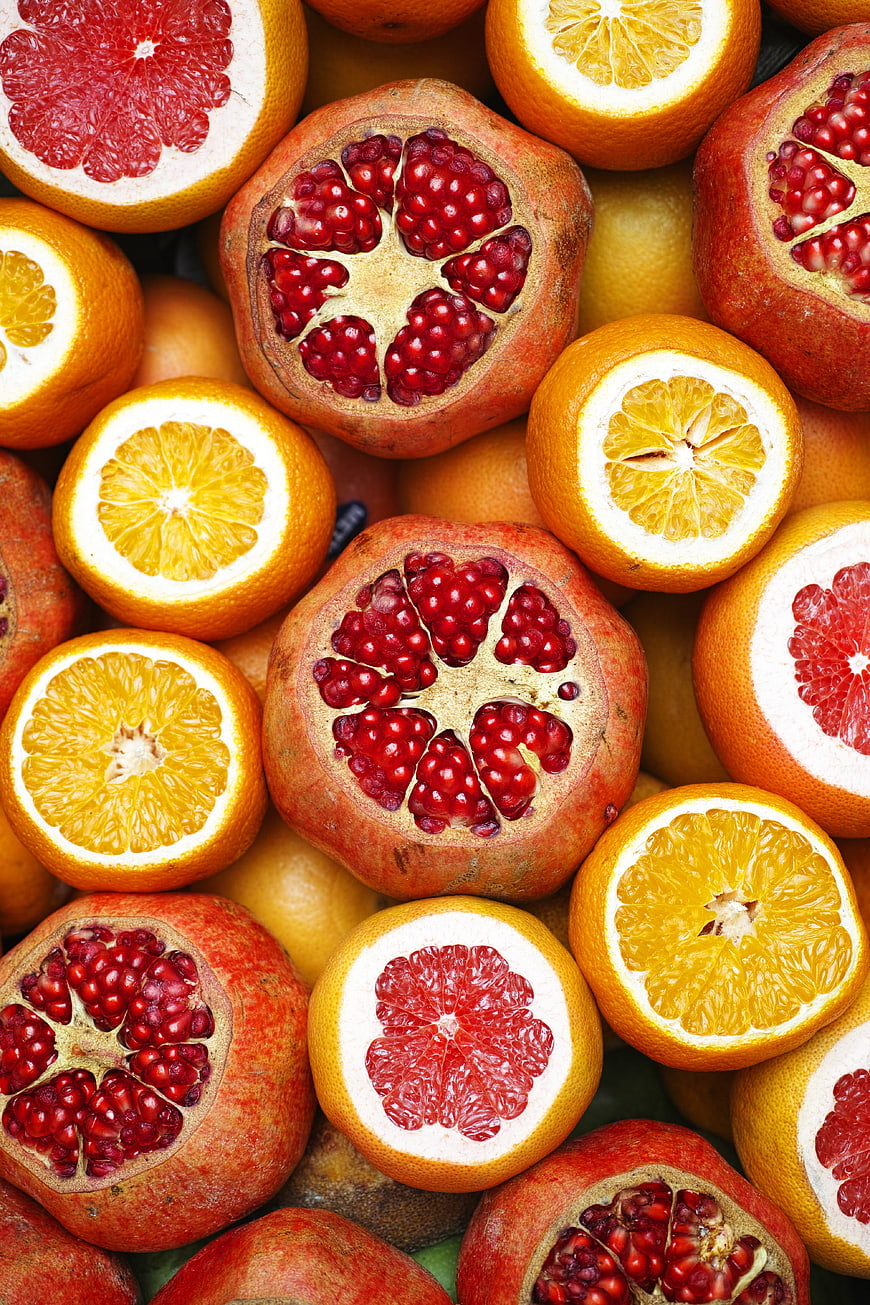 Vibrant Flat Lay of Sliced Pomegranates, Oranges, and Grapefruits