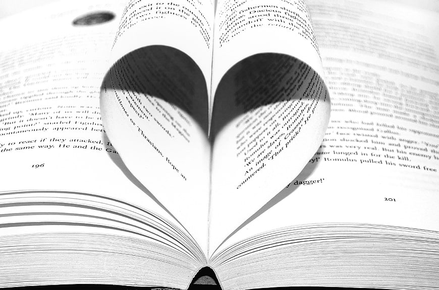 Open book pages folded into heart shape black and white