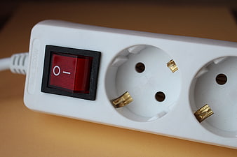 Close-up of white power strip with red switch and European sockets
