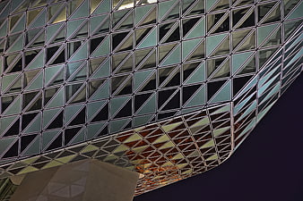 Modern geometric glass building facade at night