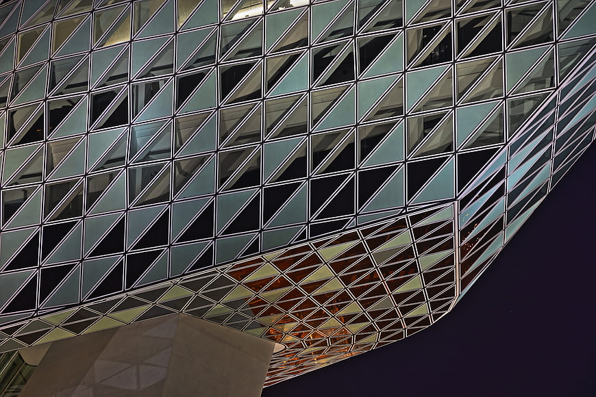 Modern geometric glass building facade at night