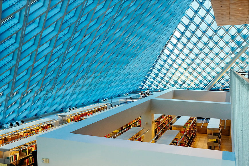 Modern library interior with blue geometric ceiling and bookshelves