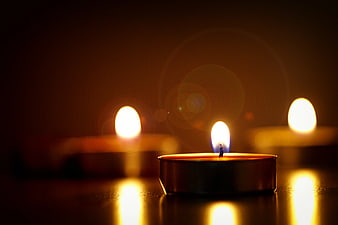 Close-up of lit tea light candles with warm bokeh