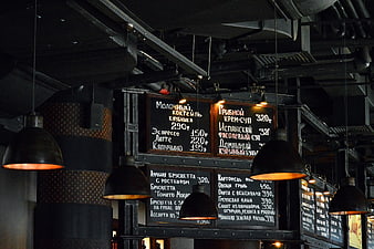 Industrial restaurant interior with hanging lamps and chalkboard menu