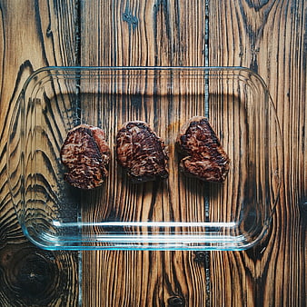 Top View of Three Cooked Beef Steaks in Glass Dish