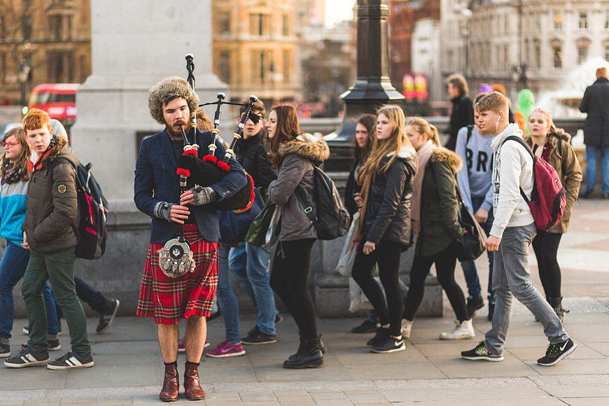 Bagpiper Busker Performing in Busy City Square
