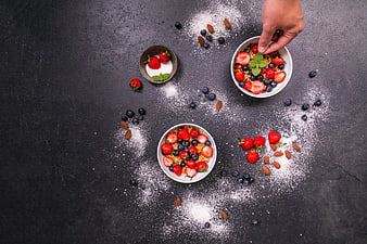Overhead view of healthy breakfast bowls with berries and yogurt