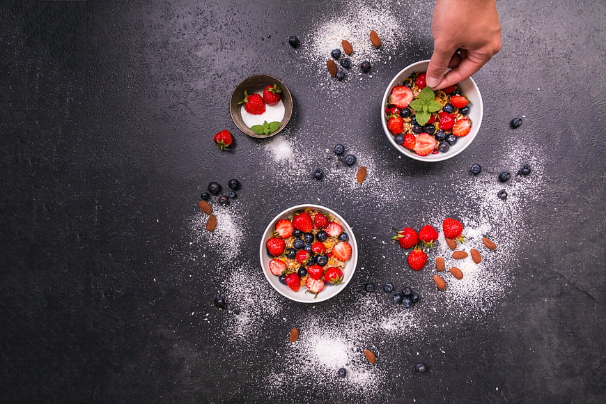 Overhead view of healthy breakfast bowls with berries and yogurt