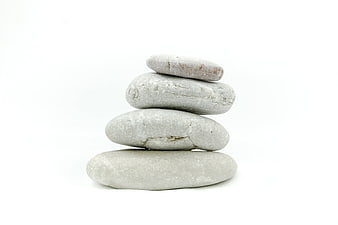 Stacked smooth gray stones on white background for zen meditation