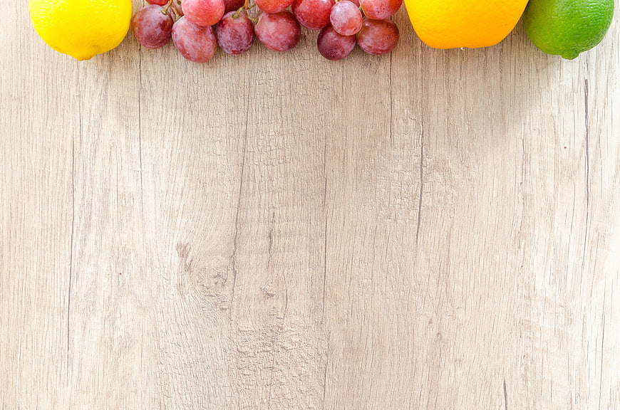 Fresh Fruit Border on Light Wooden Background with Copyspace