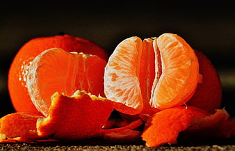Close-up of peeled tangerine segments on dark background