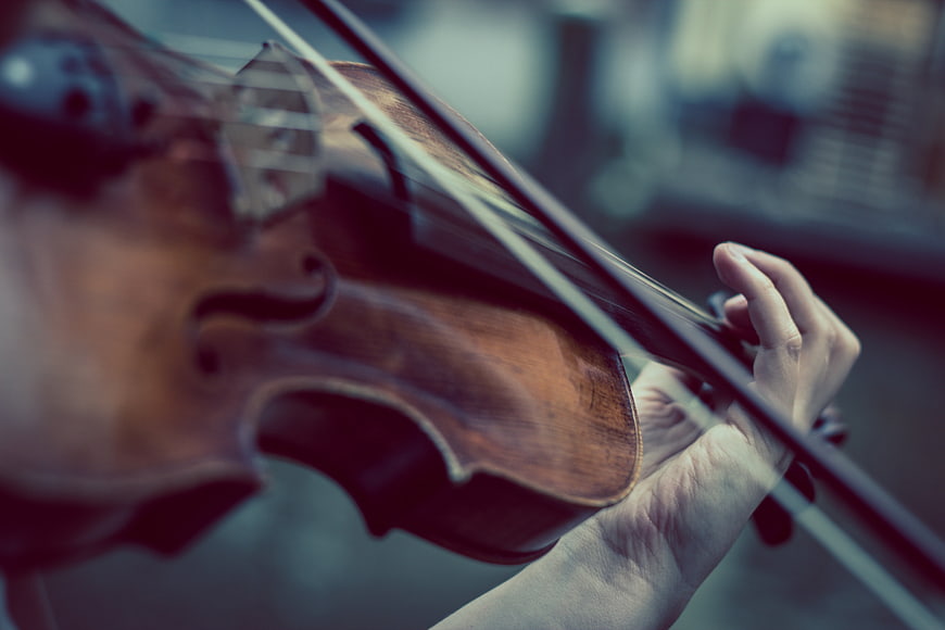Close-up of hands playing a violin with cinematic lighting