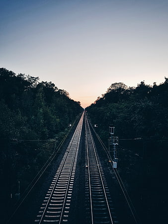 Symmetrical Railway Tracks Leading to Sunset Horizon