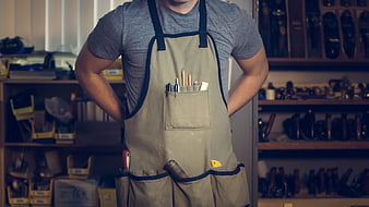 Carpenter in Apron with Tools in Workshop