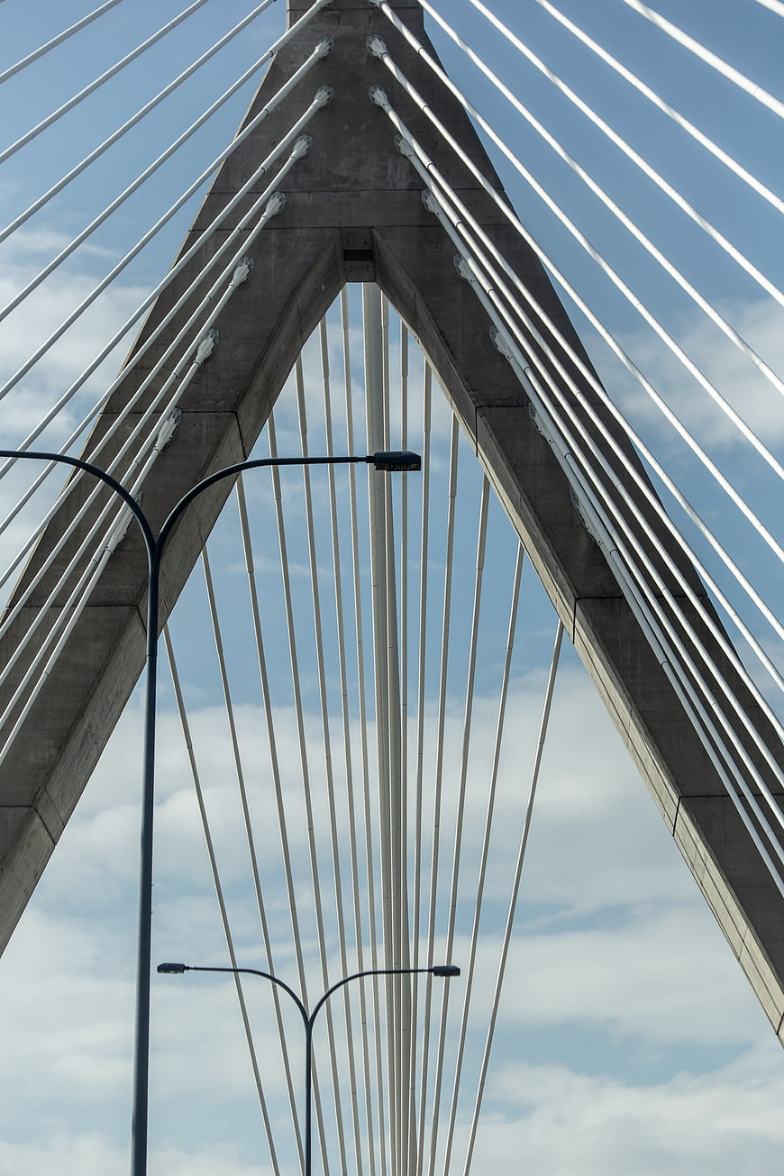 Low angle view of modern cable-stayed bridge architecture against blue sky