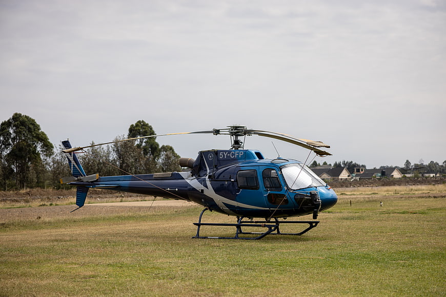 Blue Helicopter Parked on Grassy Field