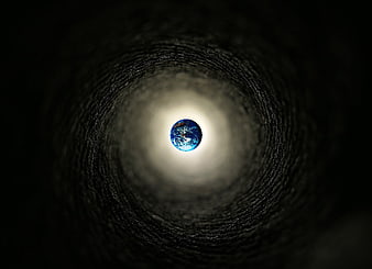 Earth globe at the end of a dark textured tunnel