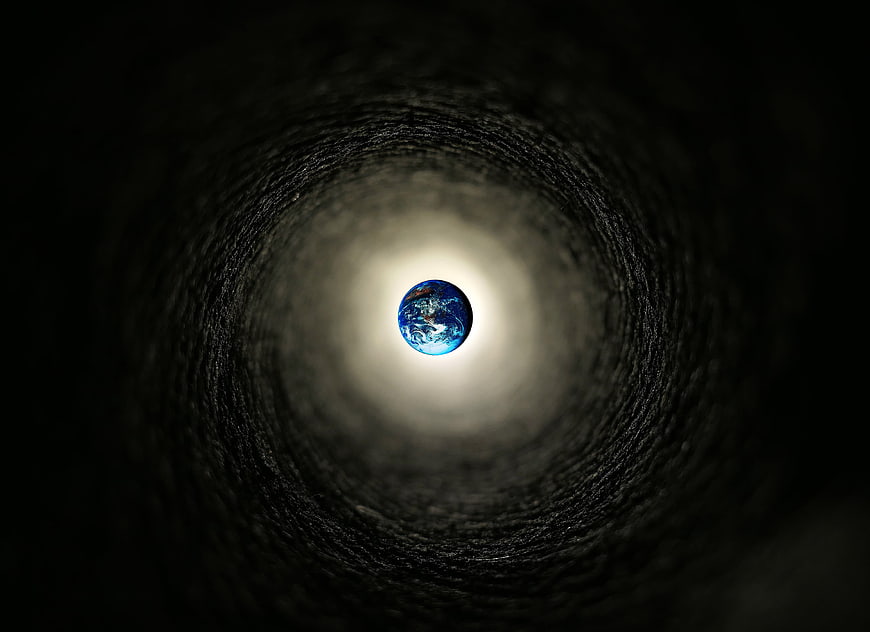 Earth globe at the end of a dark textured tunnel