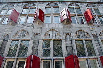 Red shutters on historic stone building facade in Utrecht